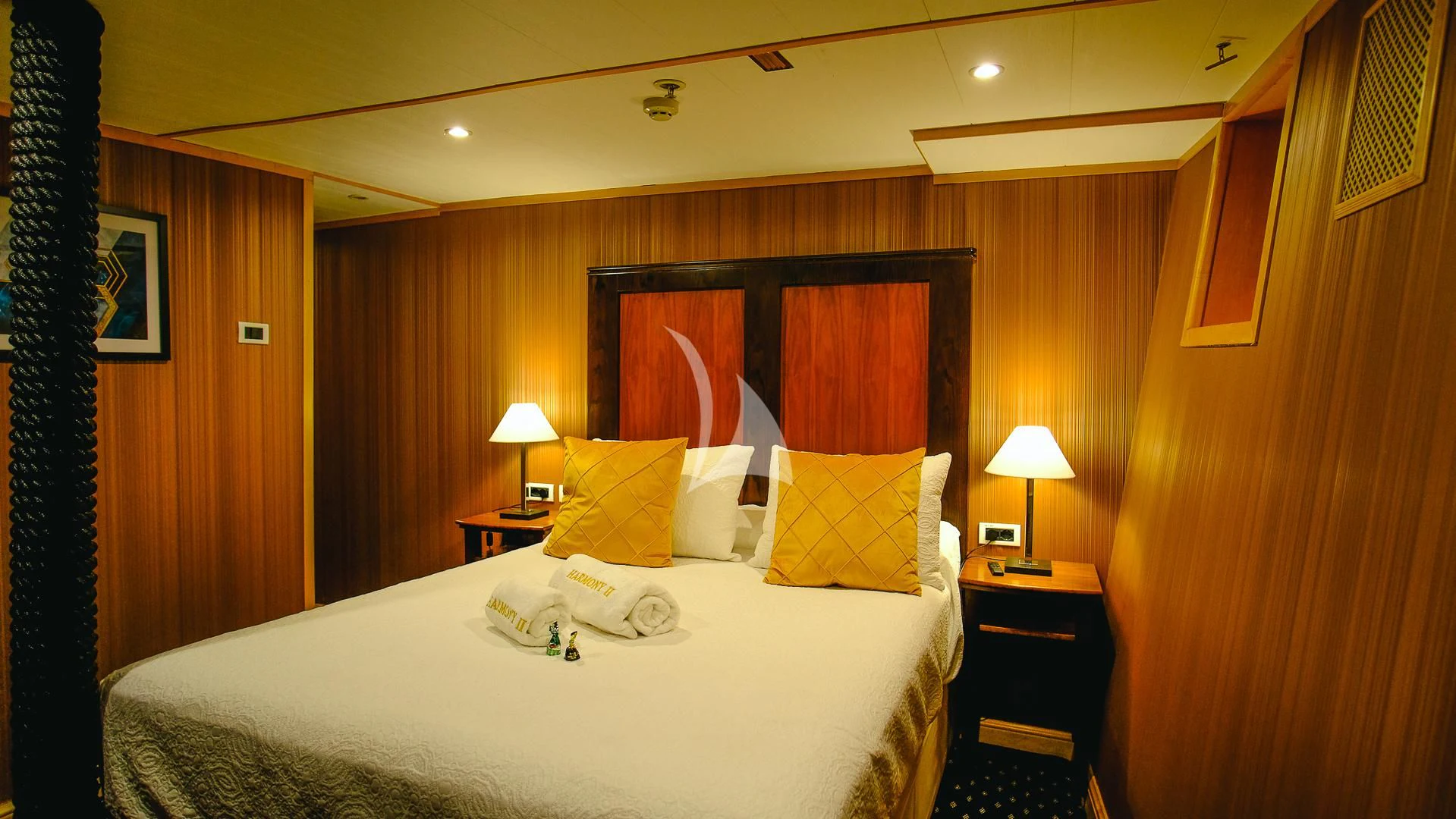 a hotel room with a bed and night stand aboard HARMONY II Yacht for Sale