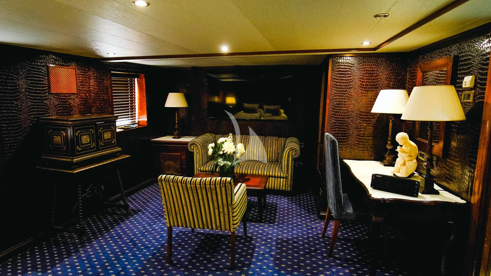 a living room with a blue rug aboard HARMONY II Yacht for Sale