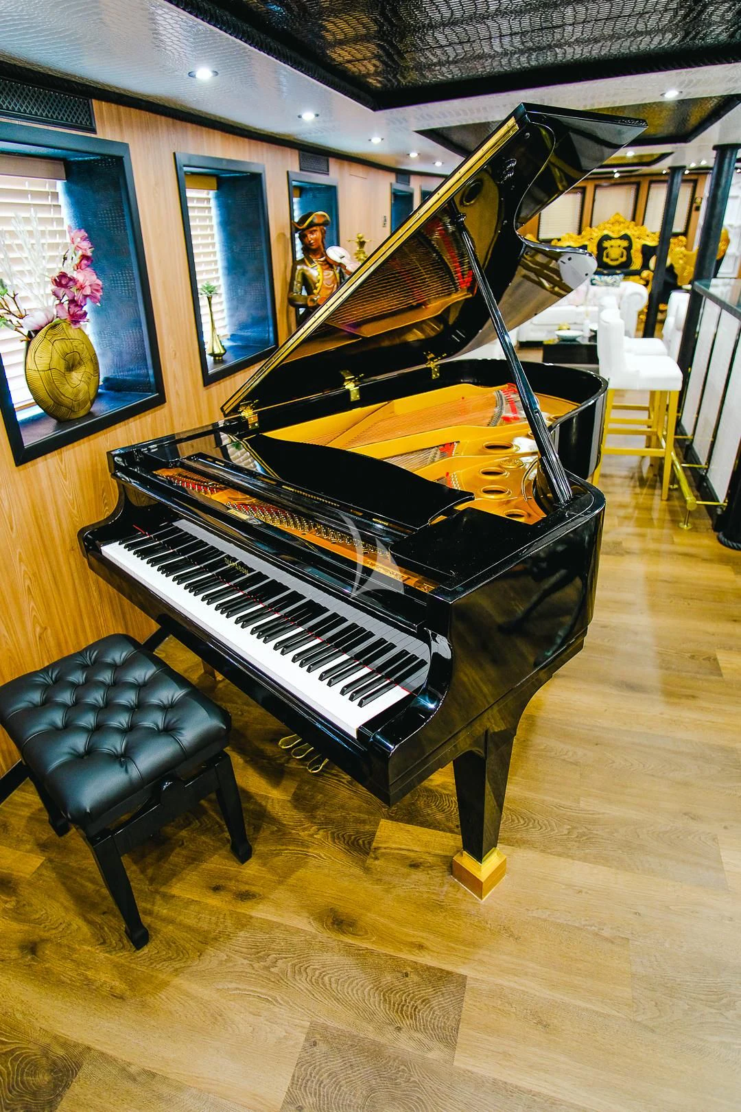 a black and gold piano aboard HARMONY II Yacht for Sale