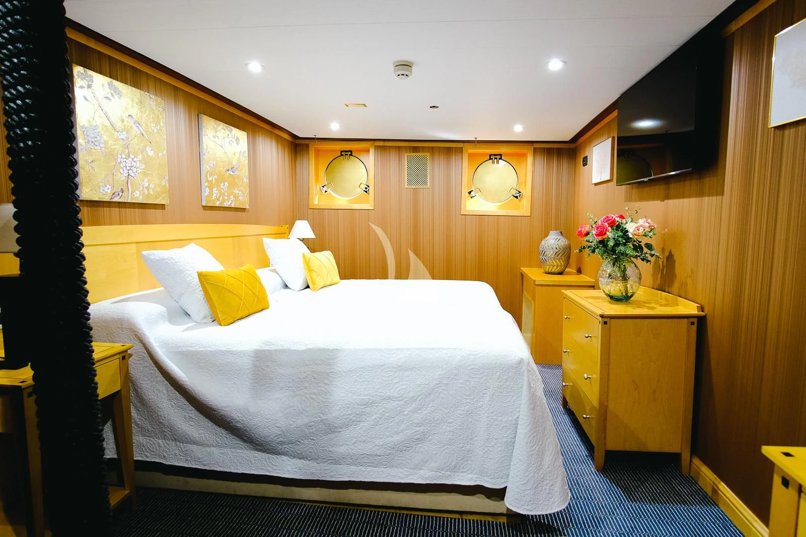 a bed with a vase of flowers on it aboard HARMONY II Yacht for Sale