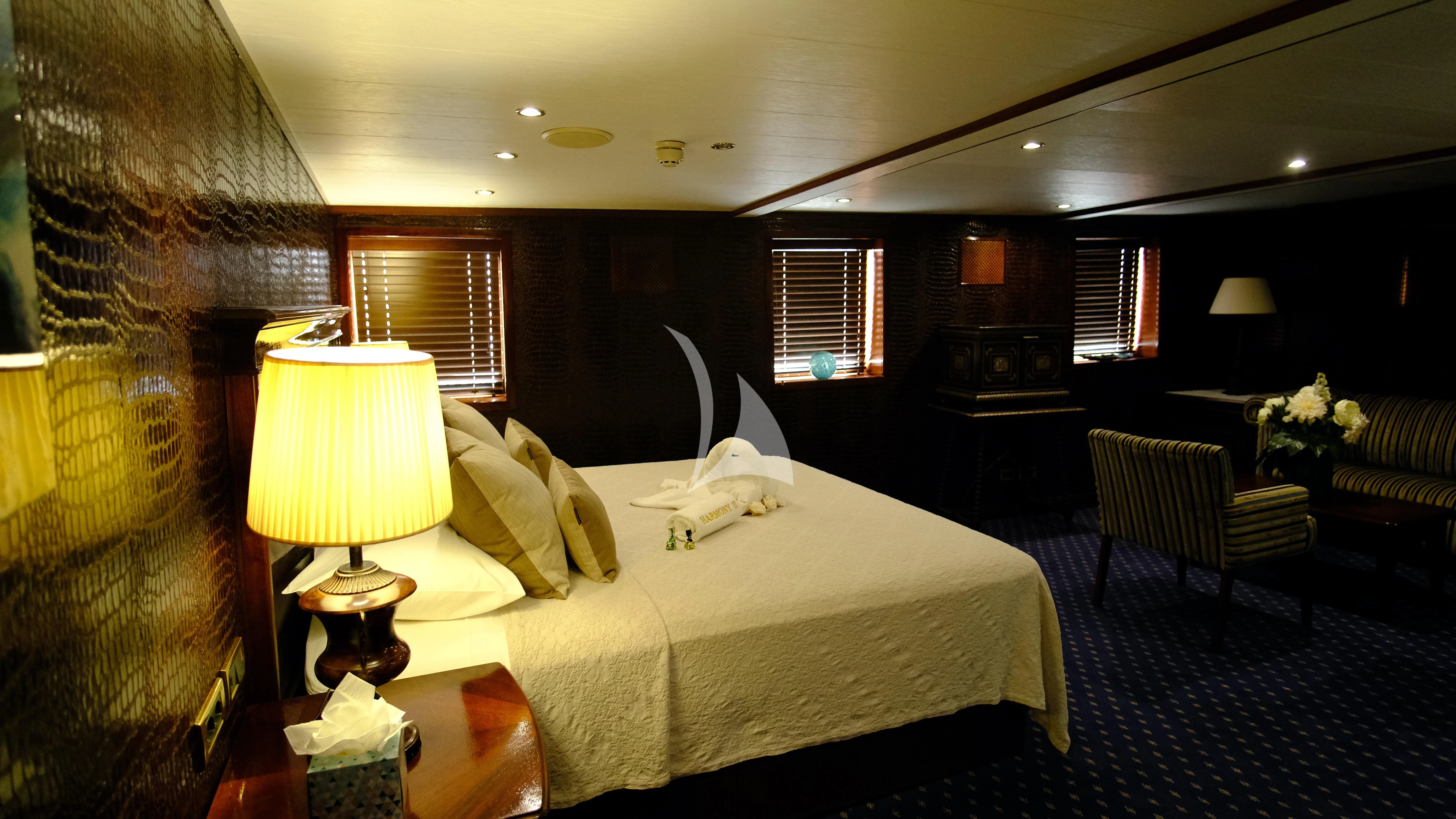 a hotel room with a bed and a chair aboard HARMONY II Yacht for Sale
