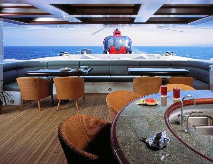 a table with chairs and a red robot on it aboard TRITON Yacht for Sale