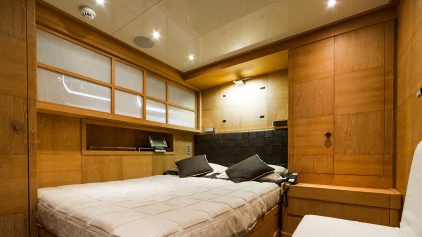 a room with a bed and a television aboard TRITON Yacht for Sale