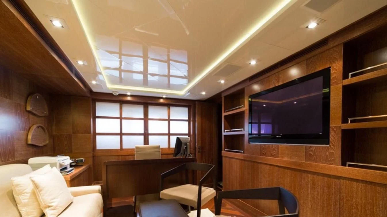 a room with a tv and a table and chairs aboard TRITON Yacht for Sale