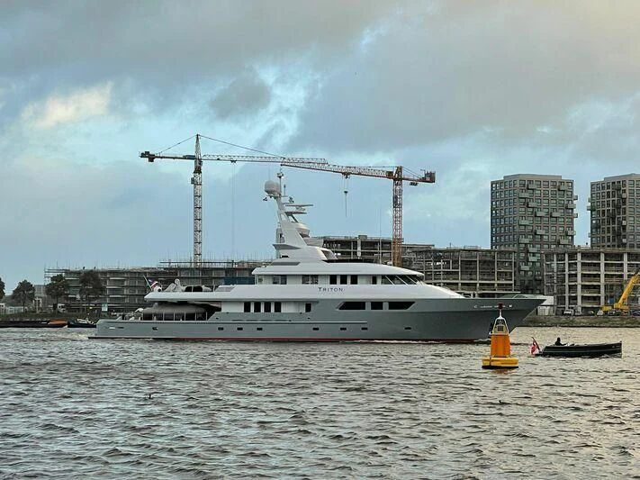a large white boat in a harbor aboard TRITON Yacht for Sale