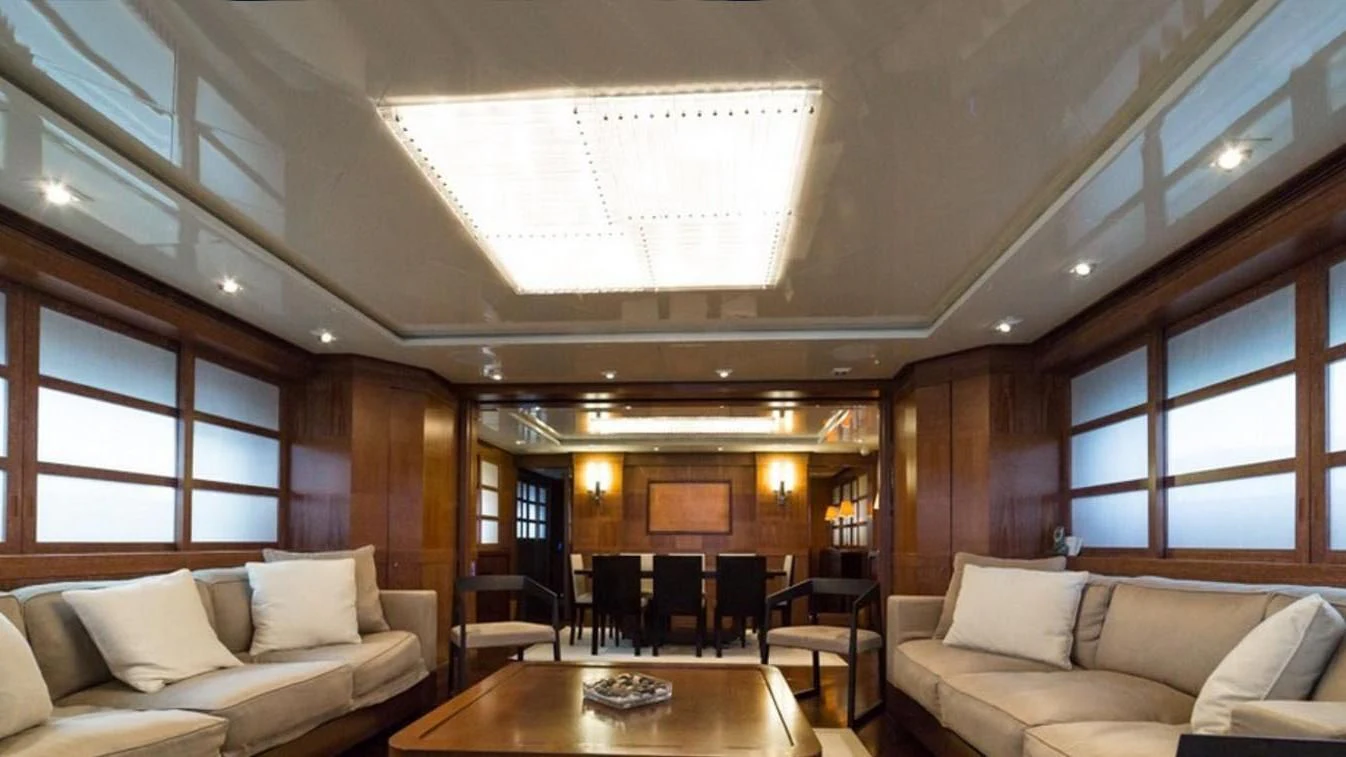 a room with a table and couches aboard TRITON Yacht for Sale