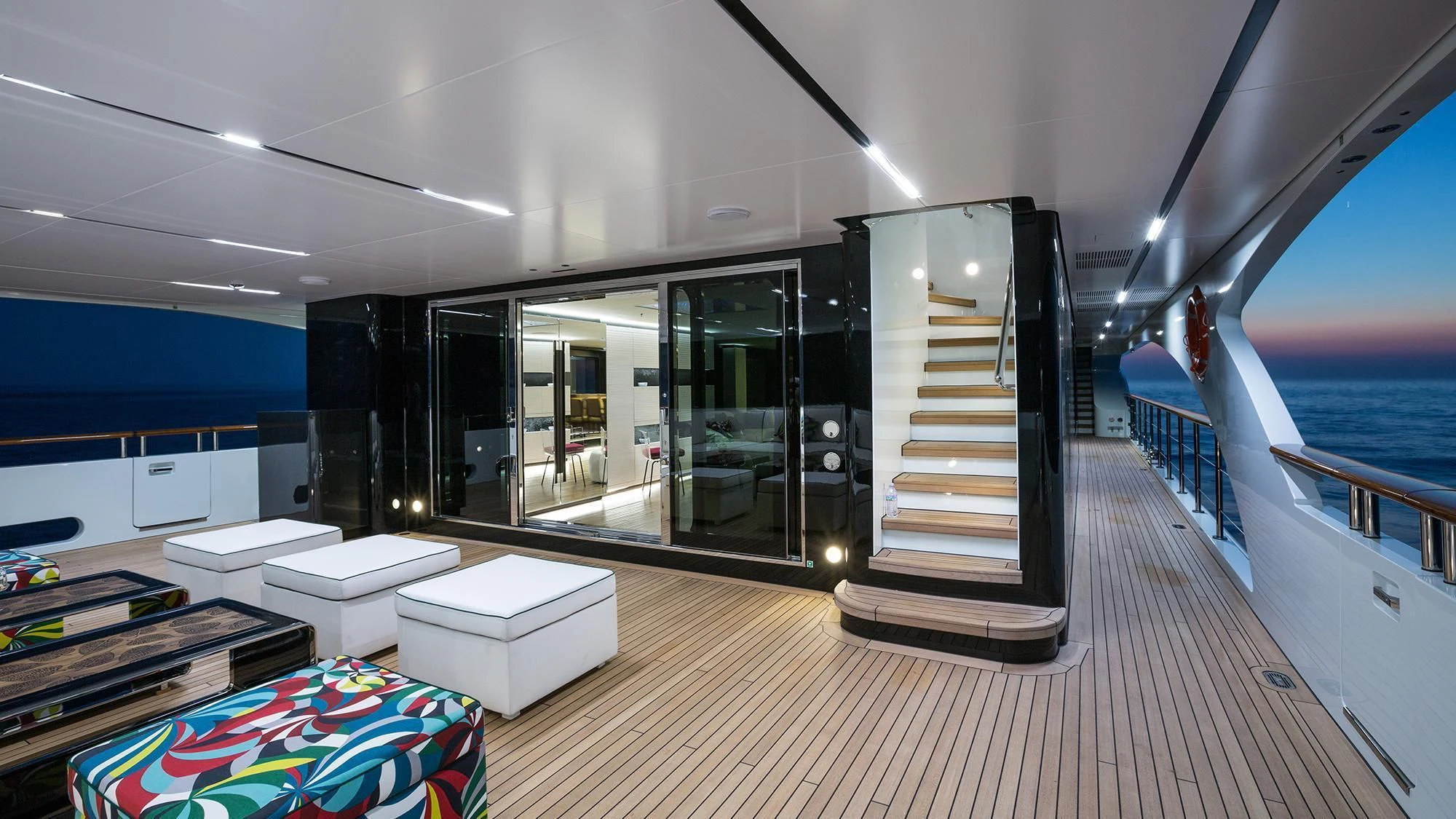 a large room with a large glass door and a deck with a view of the water aboard OCEAN PARADISE Yacht for Sale
