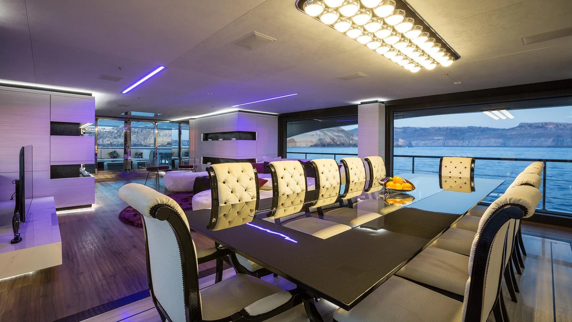 inside of a building with chairs and a table with a purple wall aboard OCEAN PARADISE Yacht for Sale