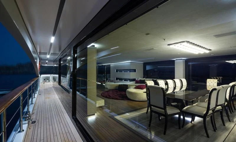 a long wooden deck with chairs and tables aboard OCEAN PARADISE Yacht for Sale