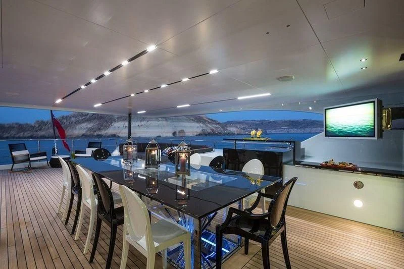 a room with a table and chairs aboard OCEAN PARADISE Yacht for Sale
