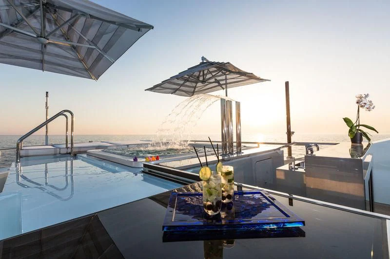 a pool with a umbrella and flowers aboard OCEAN PARADISE Yacht for Sale