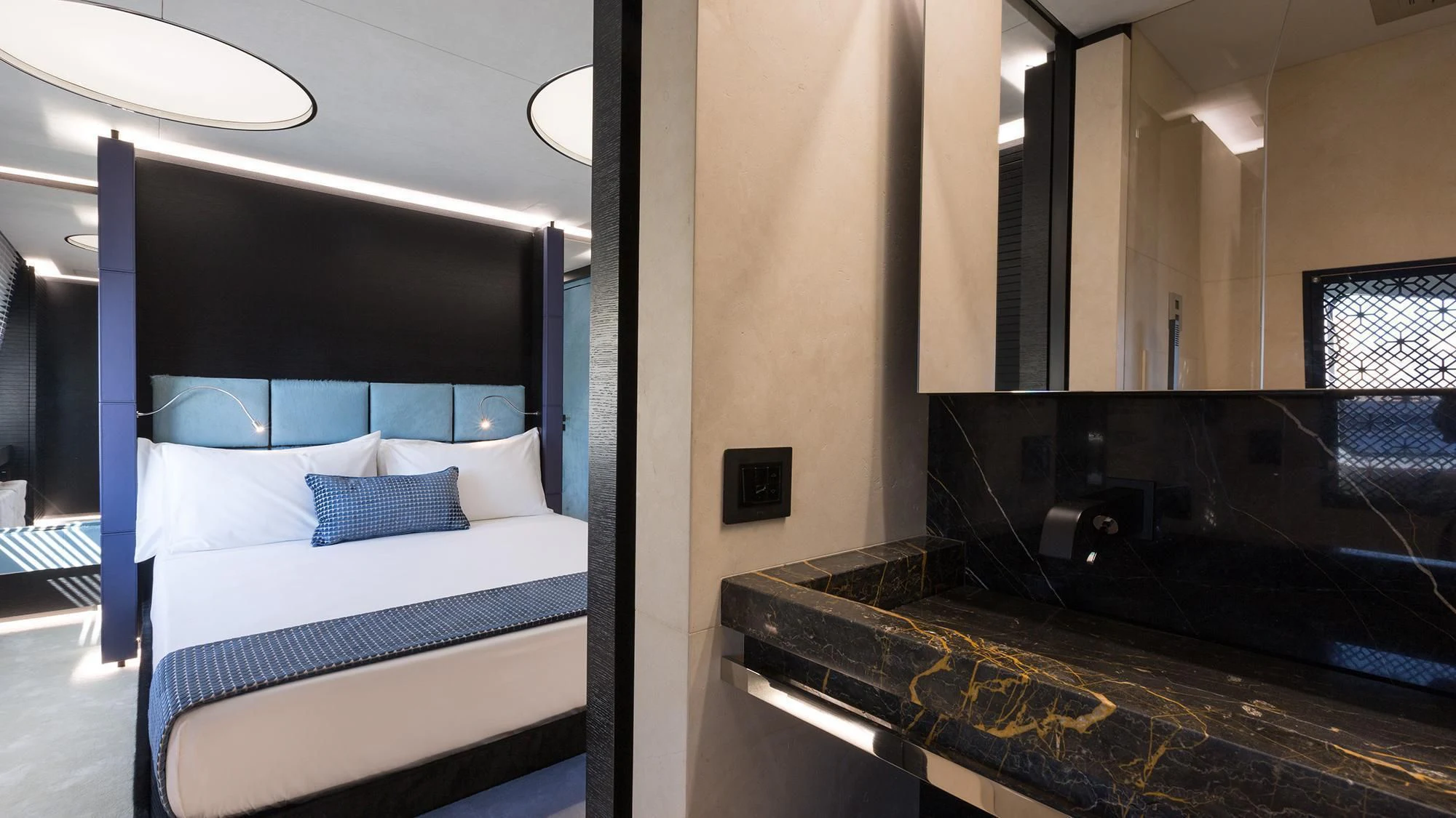 a room with a bed and a mirror aboard OCEAN PARADISE Yacht for Sale