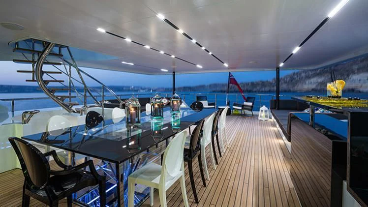 a large room with a table and chairs and a large pool aboard OCEAN PARADISE Yacht for Sale