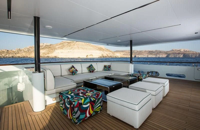 a deck with a view of the ocean and mountains aboard OCEAN PARADISE Yacht for Sale