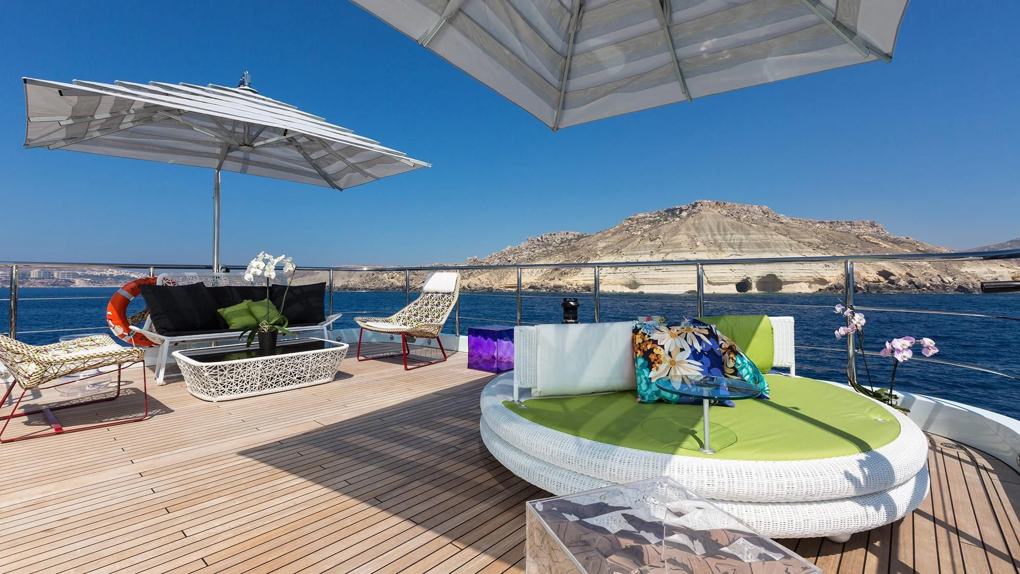 a deck with a table and chairs and umbrellas aboard OCEAN PARADISE Yacht for Sale