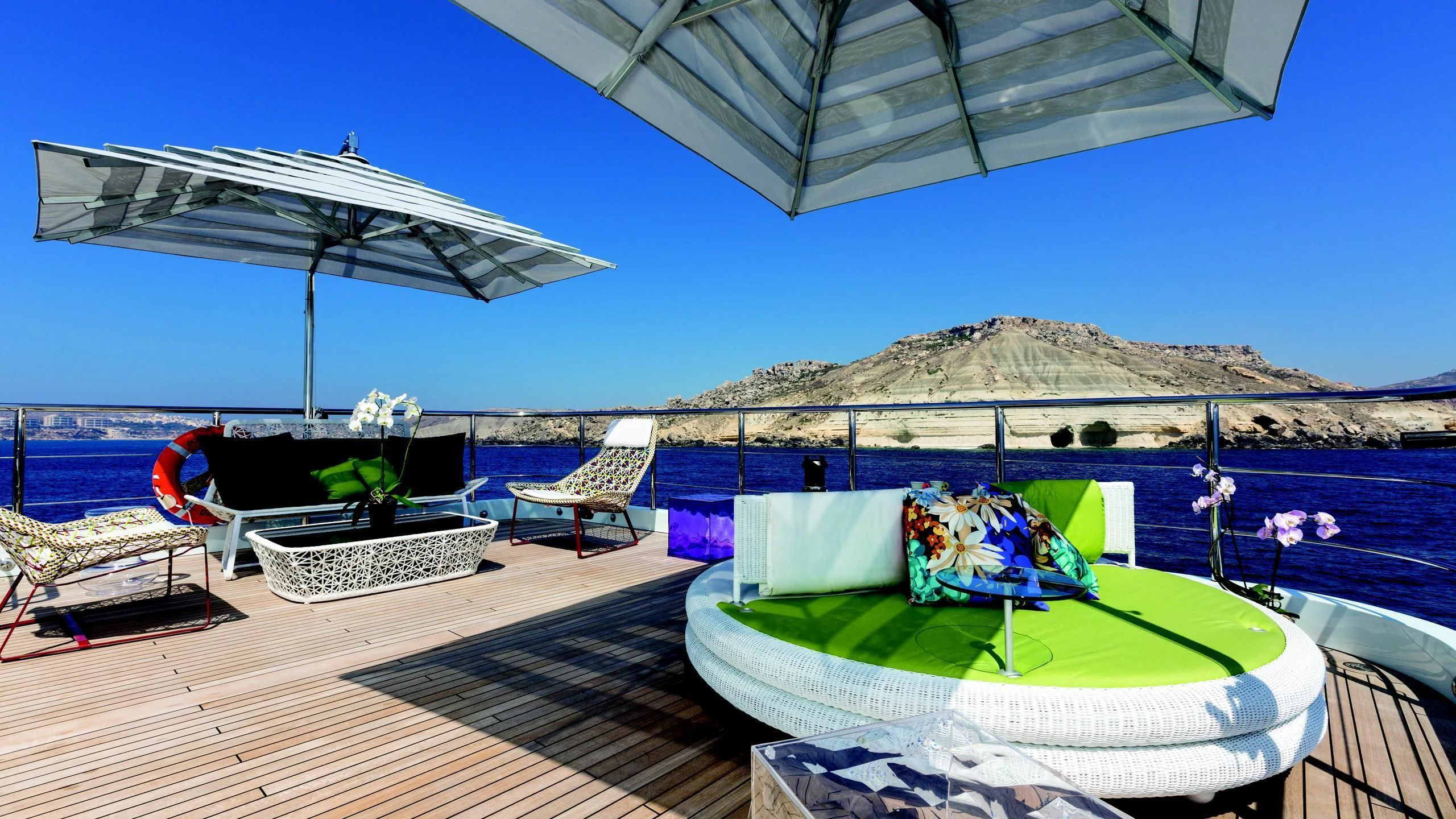 a deck with a large umbrella and chairs on it aboard OCEAN PARADISE Yacht for Sale