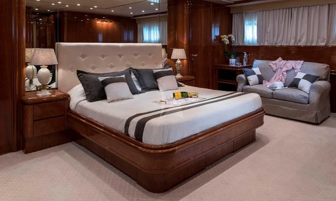 a bed with a couch and a chair in a room aboard SUGAR Yacht for Sale