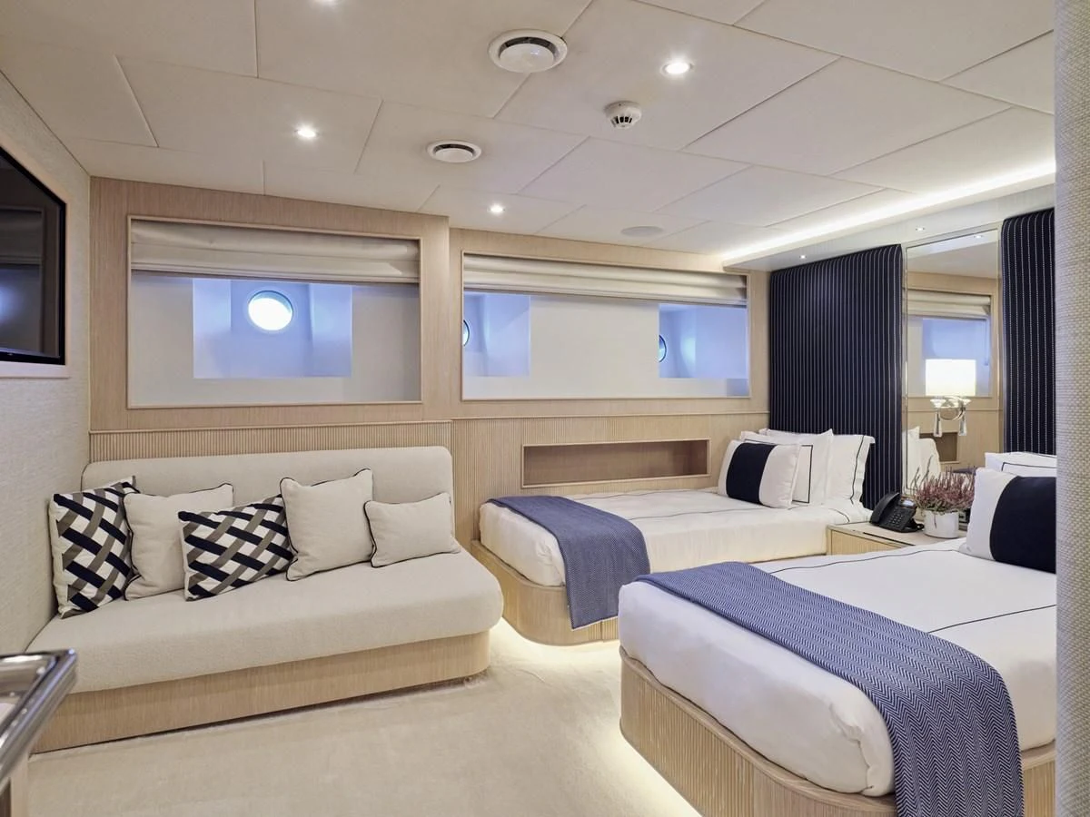 a room with a bed and a couch aboard OMNIA Yacht for Sale