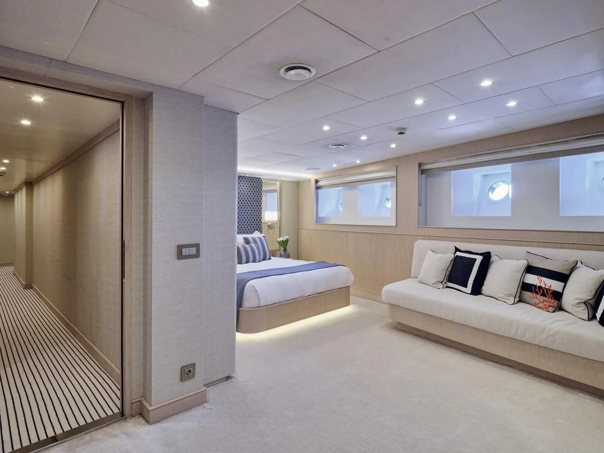 a room with a bed and a couch aboard OMNIA Yacht for Sale