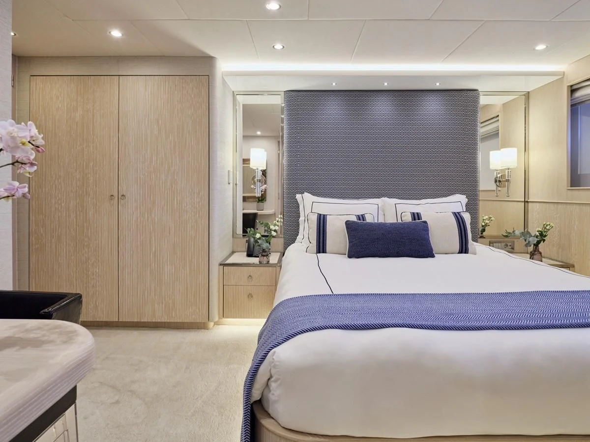 a bedroom with a bed and a desk aboard OMNIA Yacht for Sale