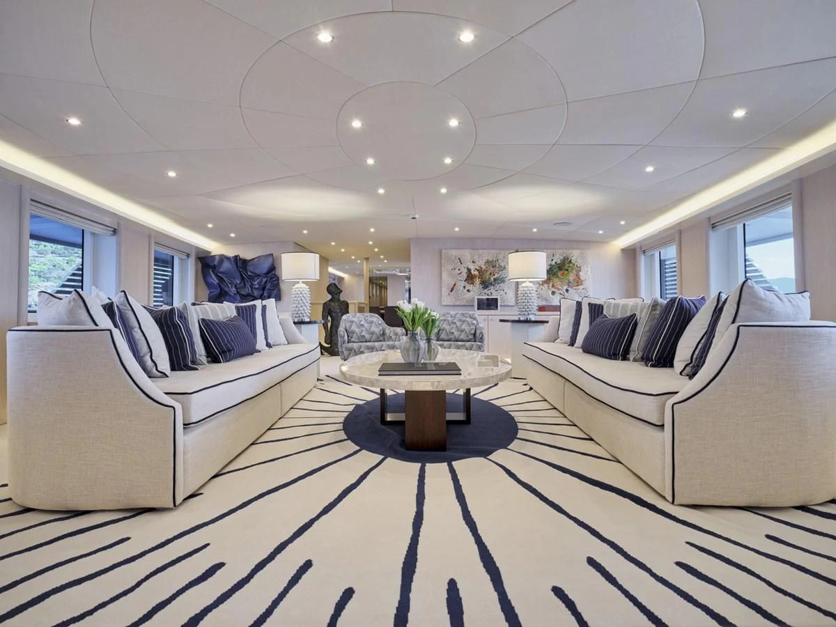 a living room with white couches aboard OMNIA Yacht for Sale