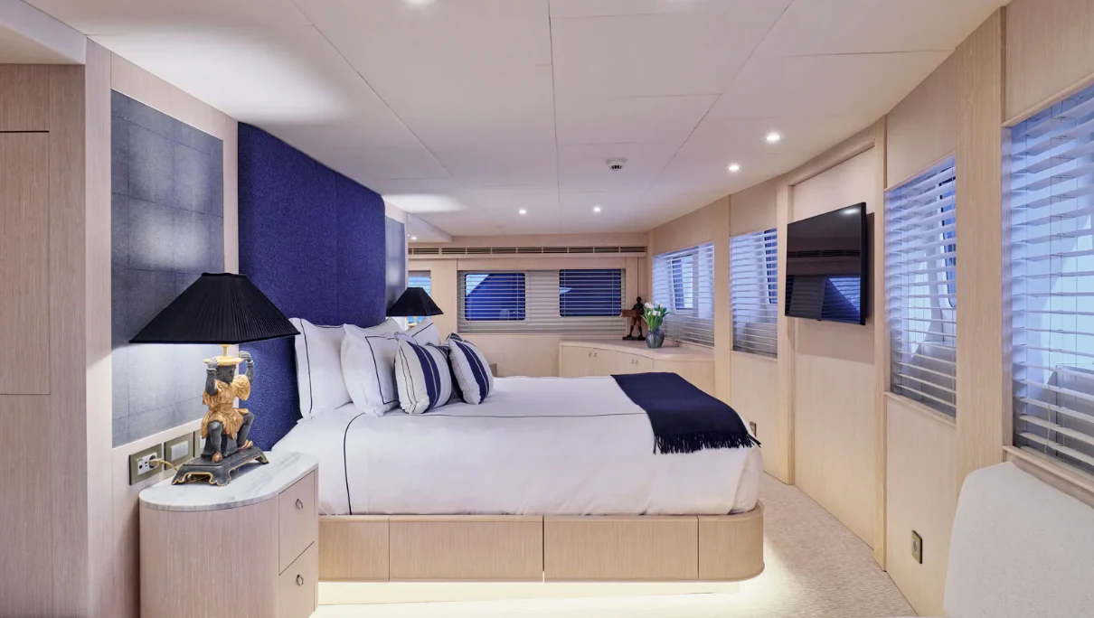 a bedroom with a bed and a lamp aboard OMNIA Yacht for Sale