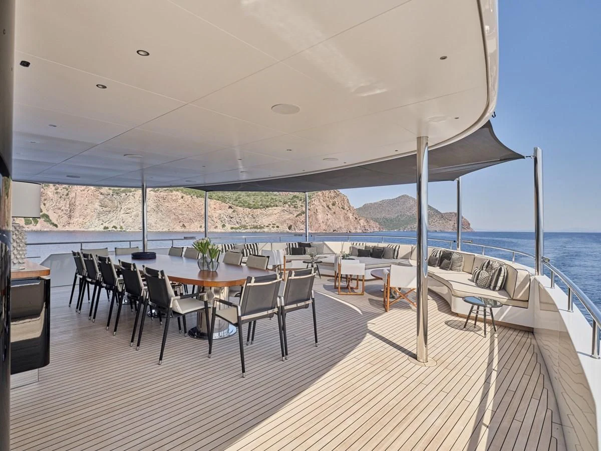 a large patio with a table and chairs on it aboard OMNIA Yacht for Sale