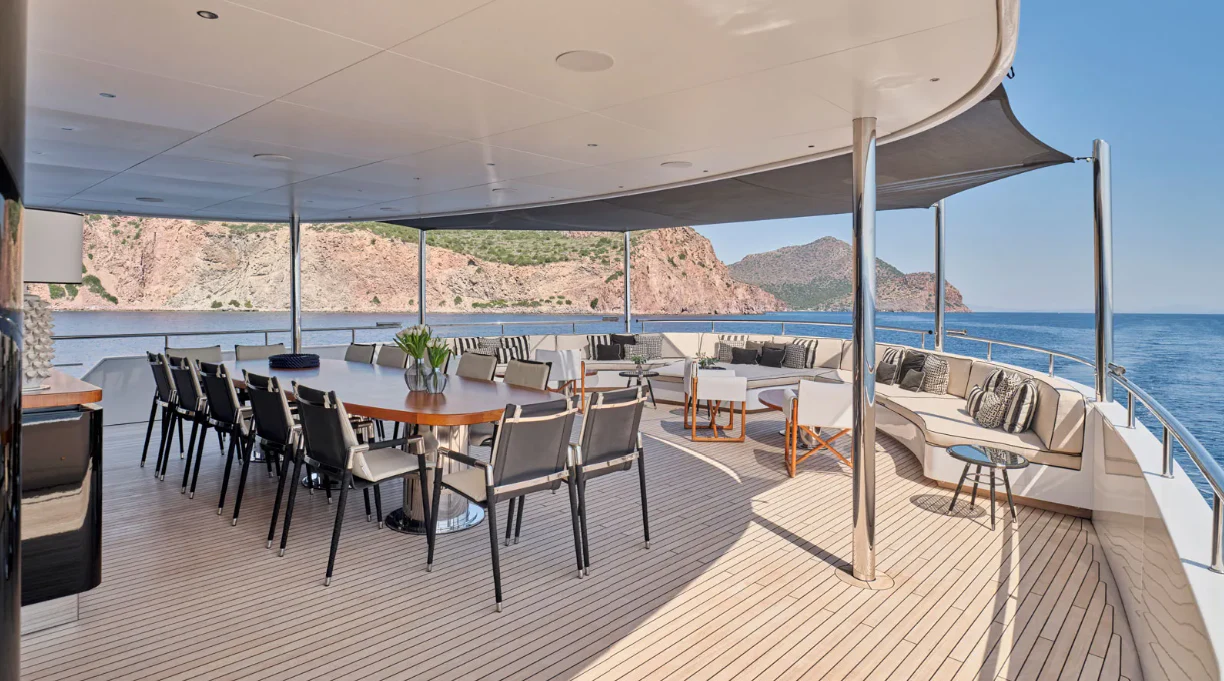 a room with tables and chairs aboard OMNIA Yacht for Sale