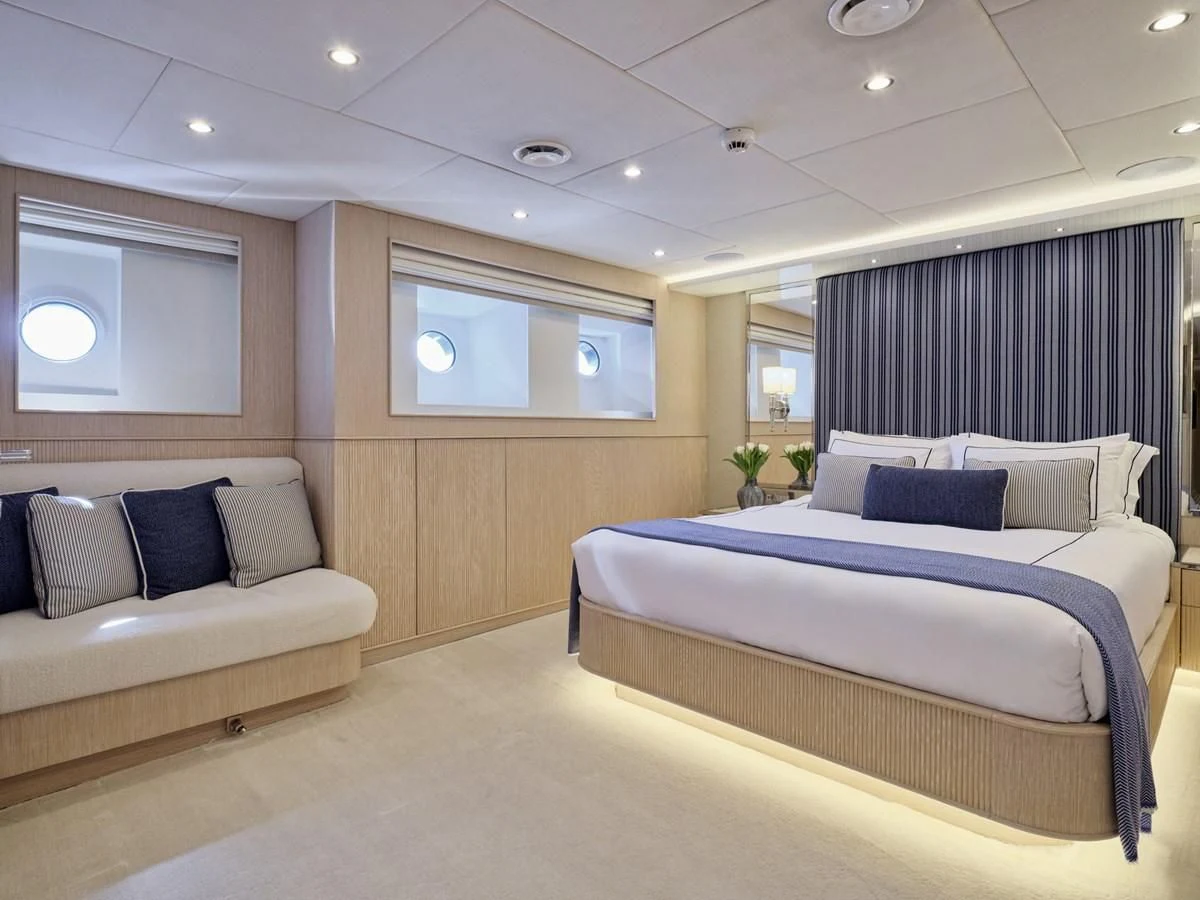 a room with a bed and a couch aboard OMNIA Yacht for Sale