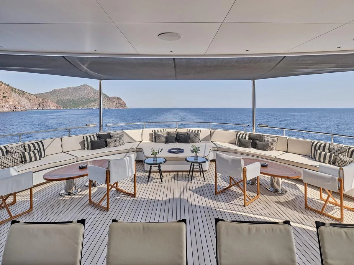 a room with tables and chairs aboard OMNIA Yacht for Sale