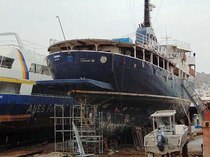 a large blue and black boat aboard OMNIA Yacht for Sale