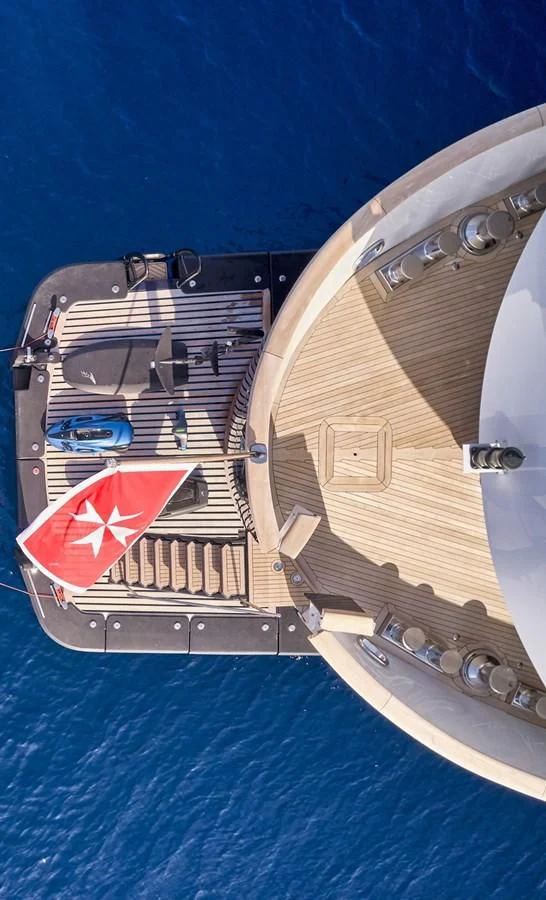 a ship with a flag on the front aboard OMNIA Yacht for Sale