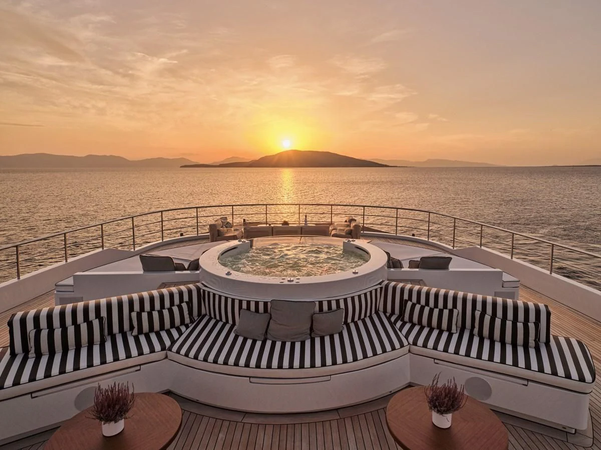 a large white boat on a large body of water aboard OMNIA Yacht for Sale