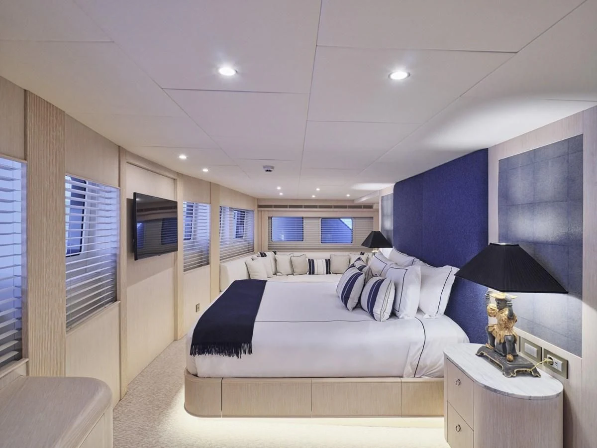 a bedroom with a bed and a desk aboard OMNIA Yacht for Sale