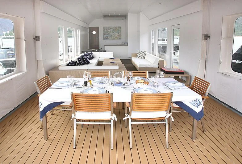 a dining room with a table and chairs aboard OMNIA Yacht for Sale
