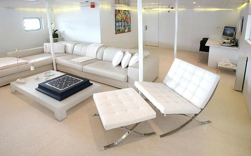 a room with a couch and a table aboard OMNIA Yacht for Sale