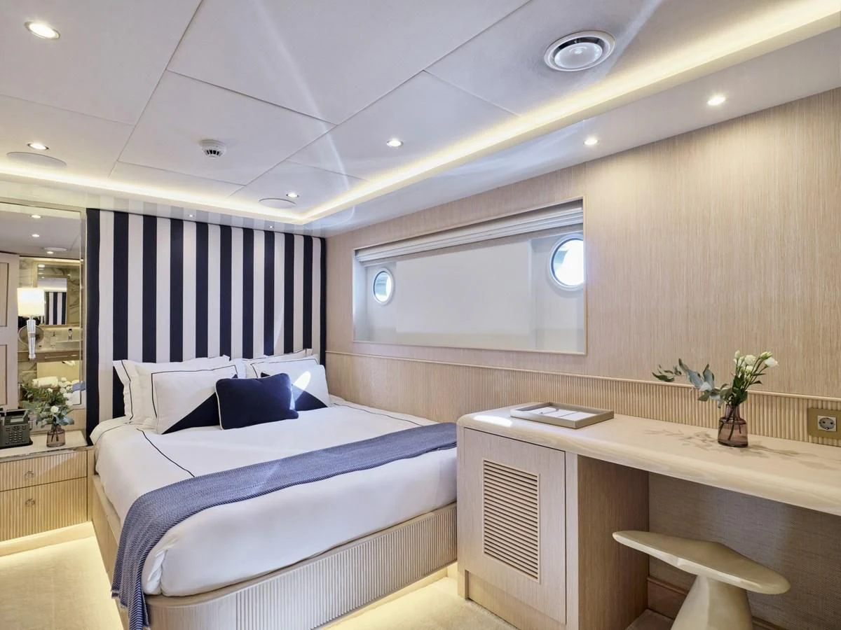 a room with a bed and a desk aboard OMNIA Yacht for Sale