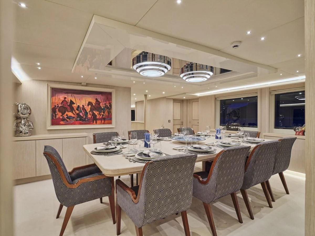 a large dining room with a table and chairs aboard OMNIA Yacht for Sale