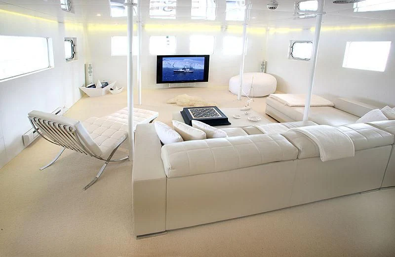 a room with a couch and a laptop on the table aboard OMNIA Yacht for Sale