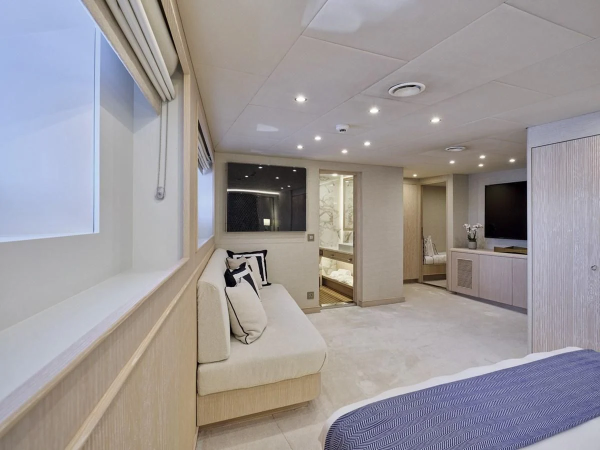 a bedroom with a bed and a tv aboard OMNIA Yacht for Sale