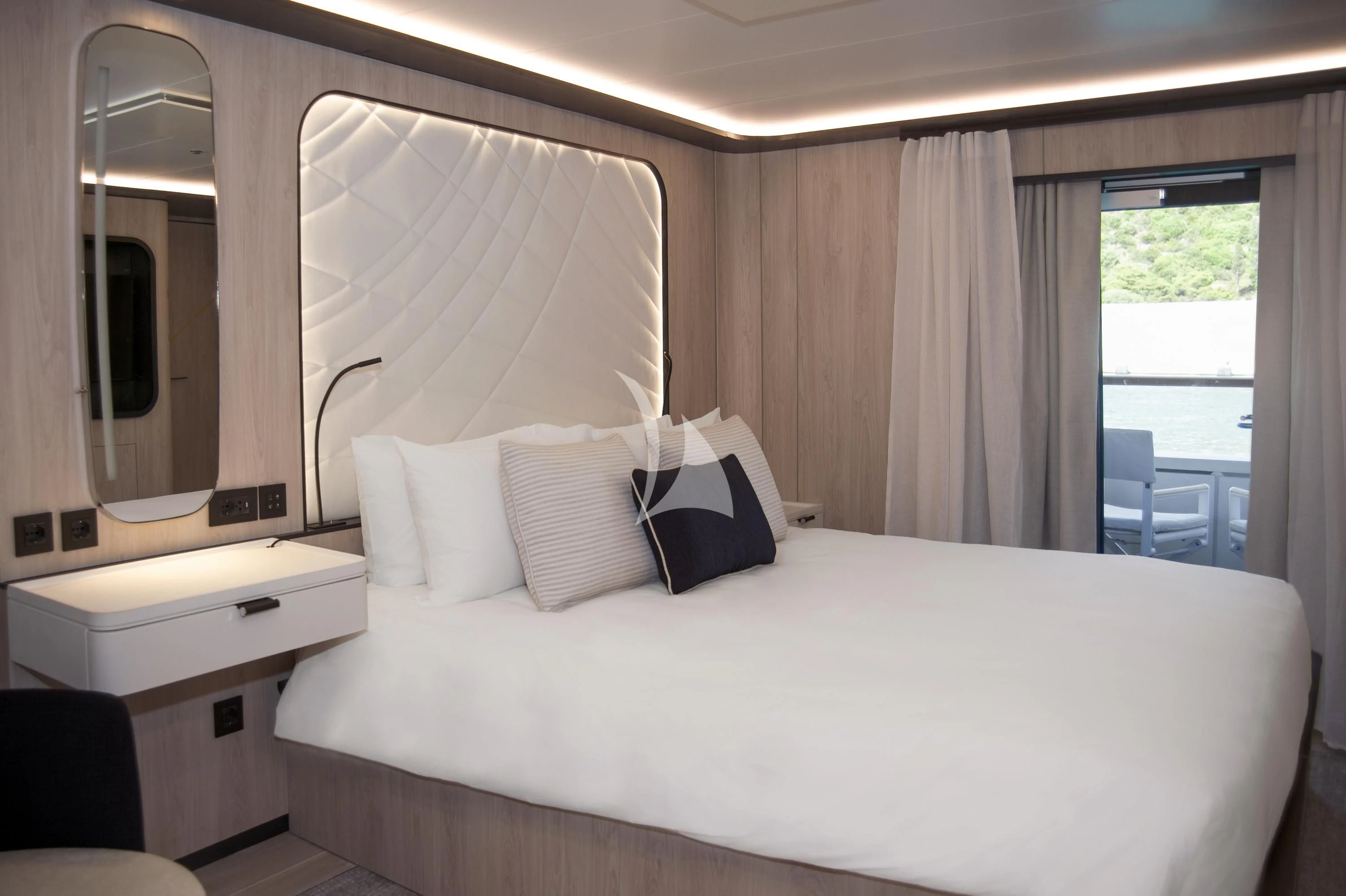 a hotel room with a bed and a desk aboard LE PONANT Yacht for Charter
