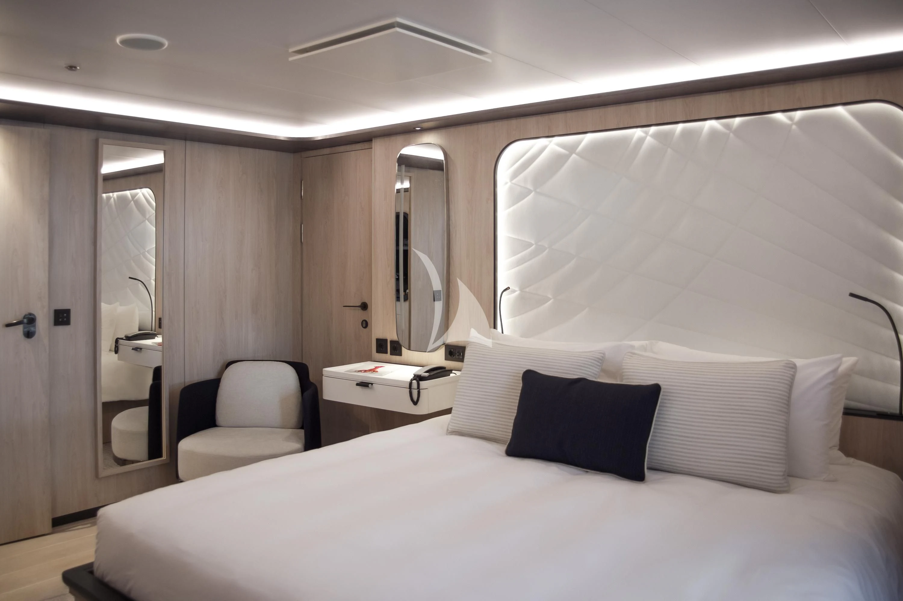 a bed with white sheets and pillows aboard LE PONANT Yacht for Charter