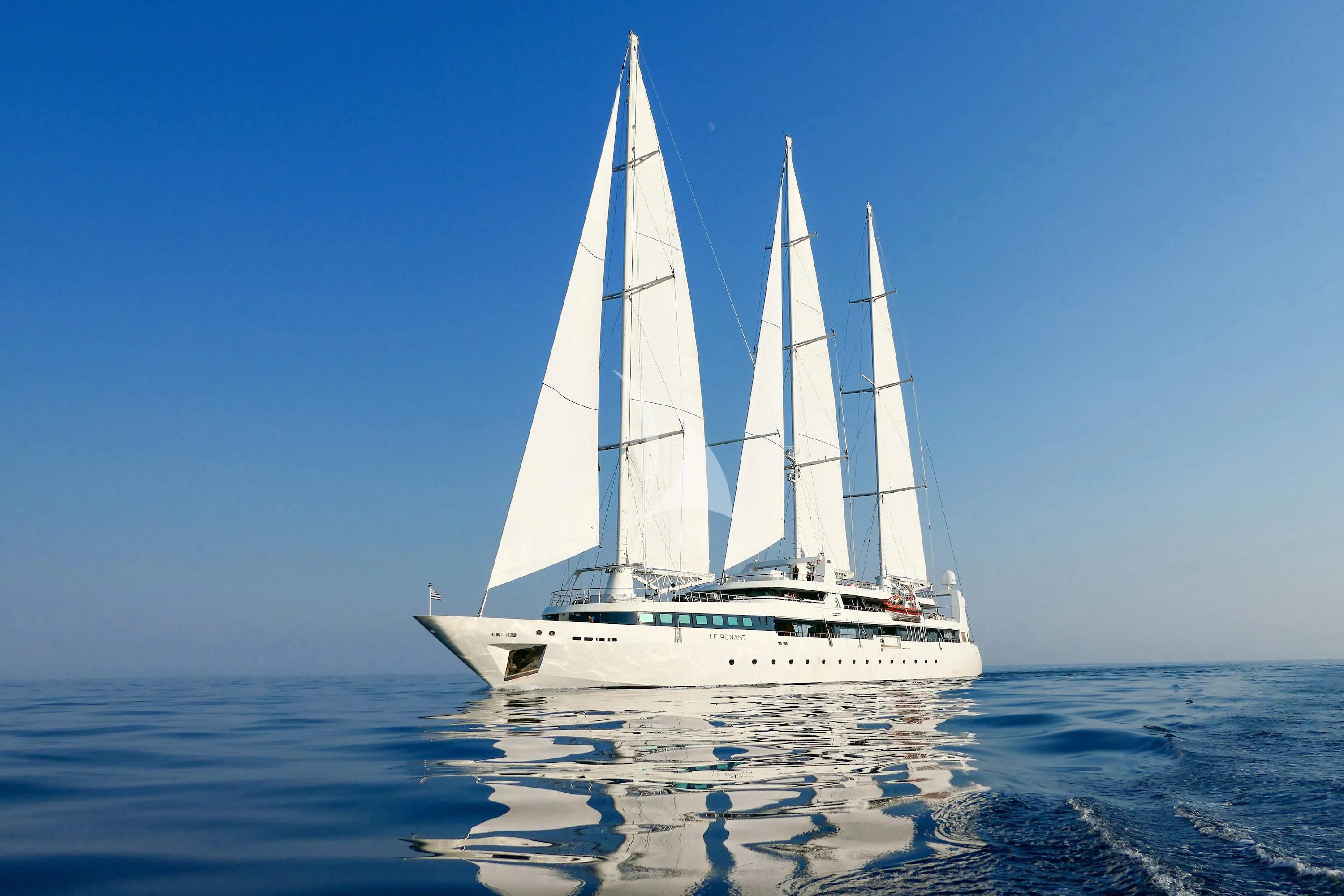 a white sailboat on the water aboard LE PONANT Yacht for Charter