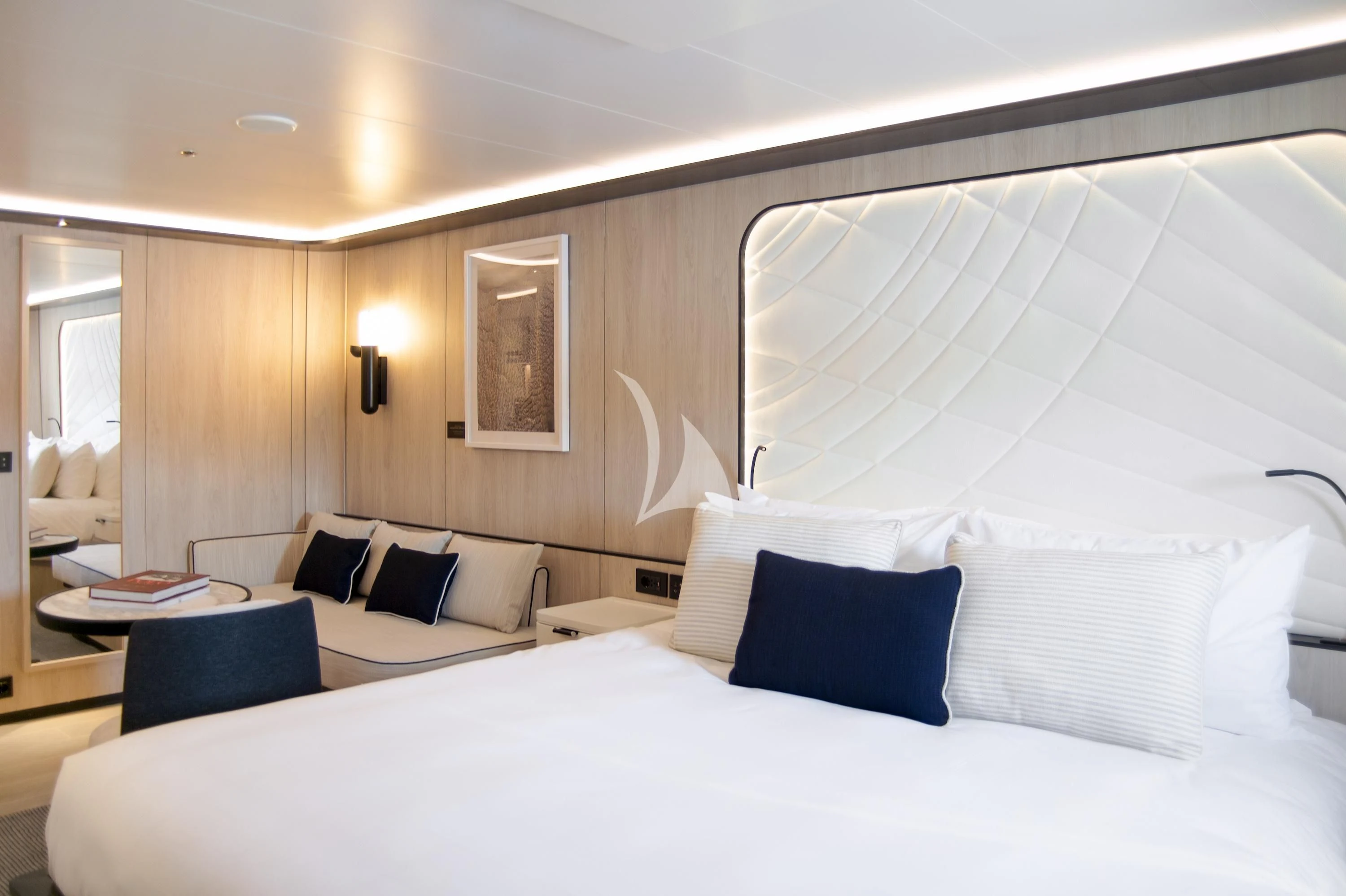 a hotel room with a bed and a white bed aboard LE PONANT Yacht for Charter