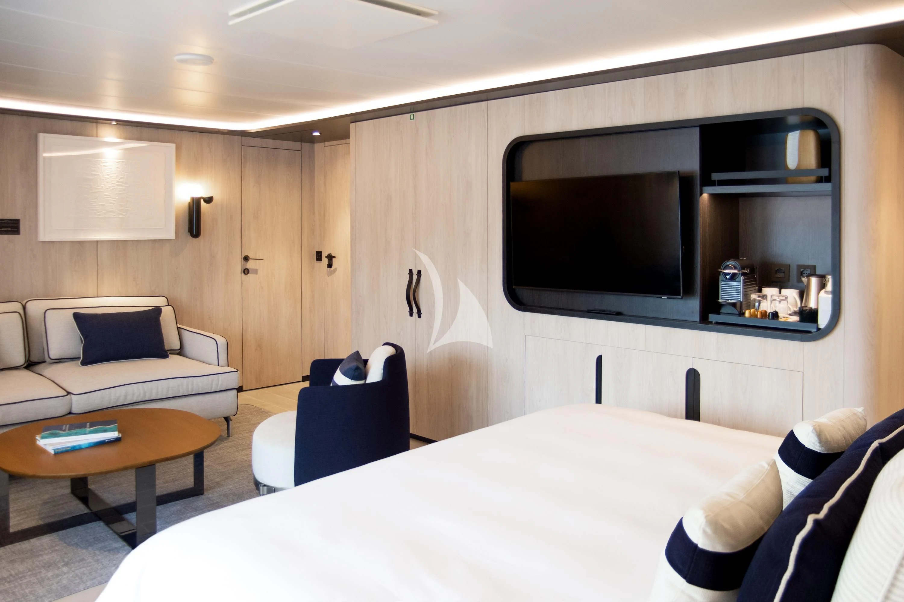 a room with a bed and a television aboard LE PONANT Yacht for Charter