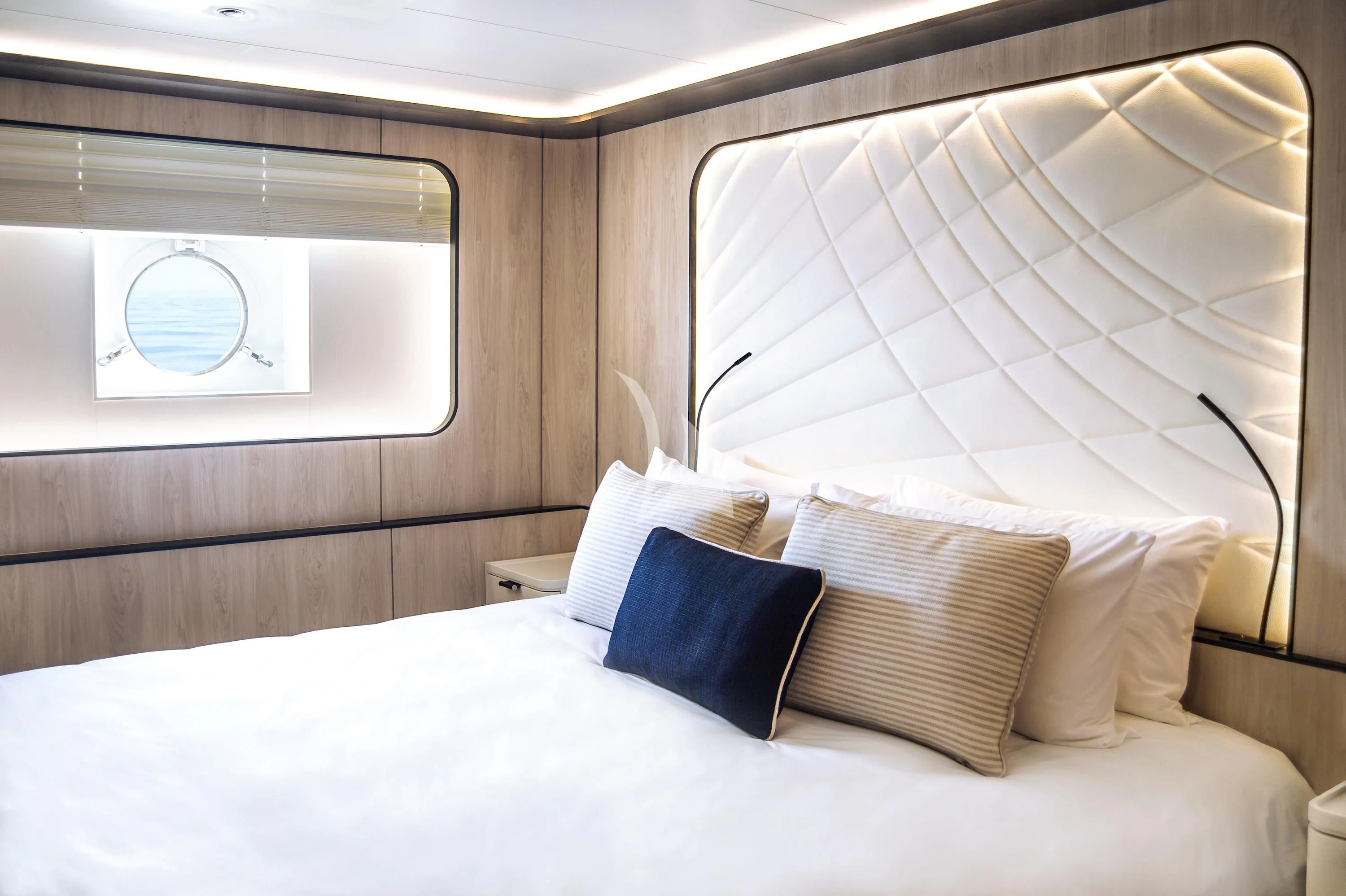 a bed with pillows aboard LE PONANT Yacht for Charter