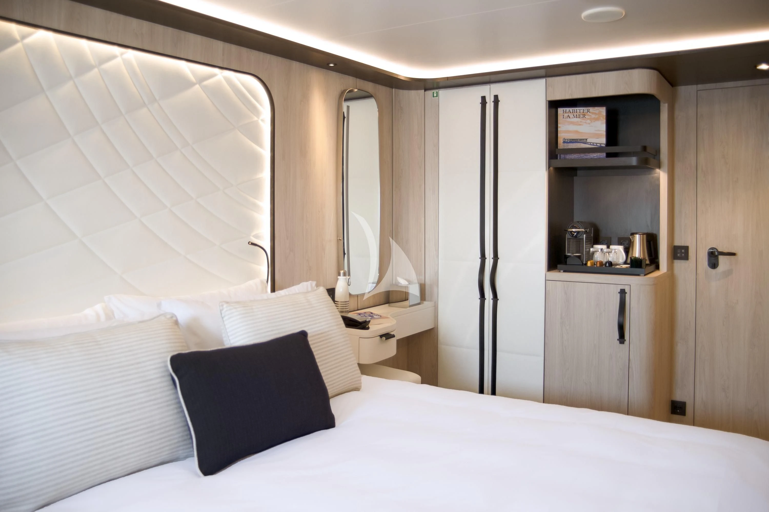 a bed with white sheets aboard LE PONANT Yacht for Charter
