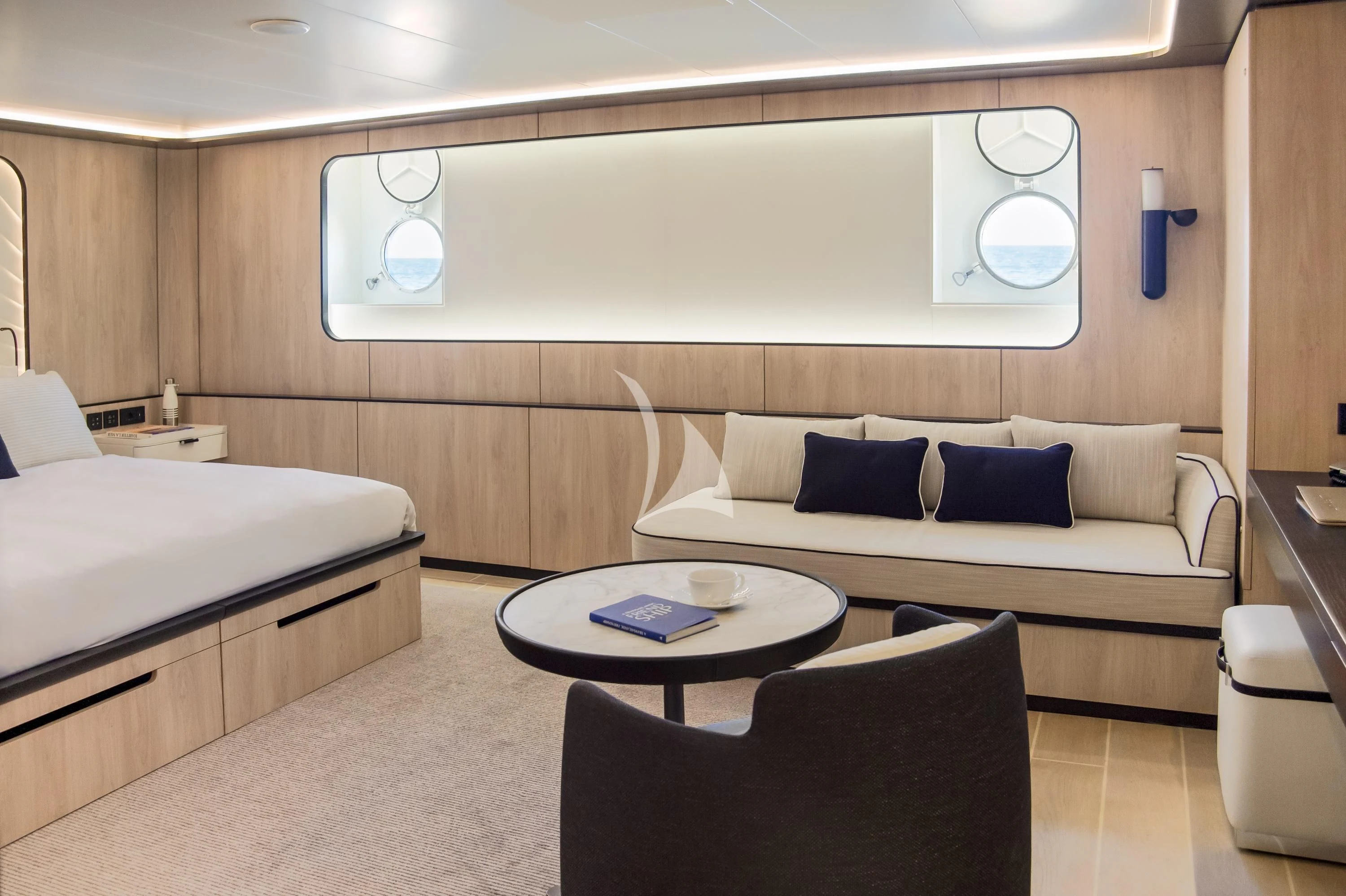a room with a bed and a coffee table aboard LE PONANT Yacht for Charter