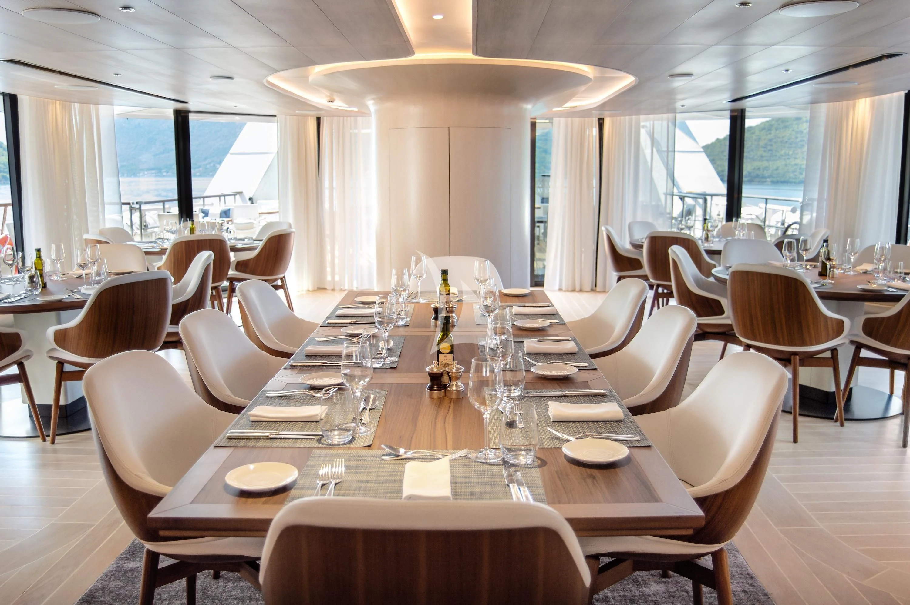 a dining room with tables and chairs aboard LE PONANT Yacht for Charter