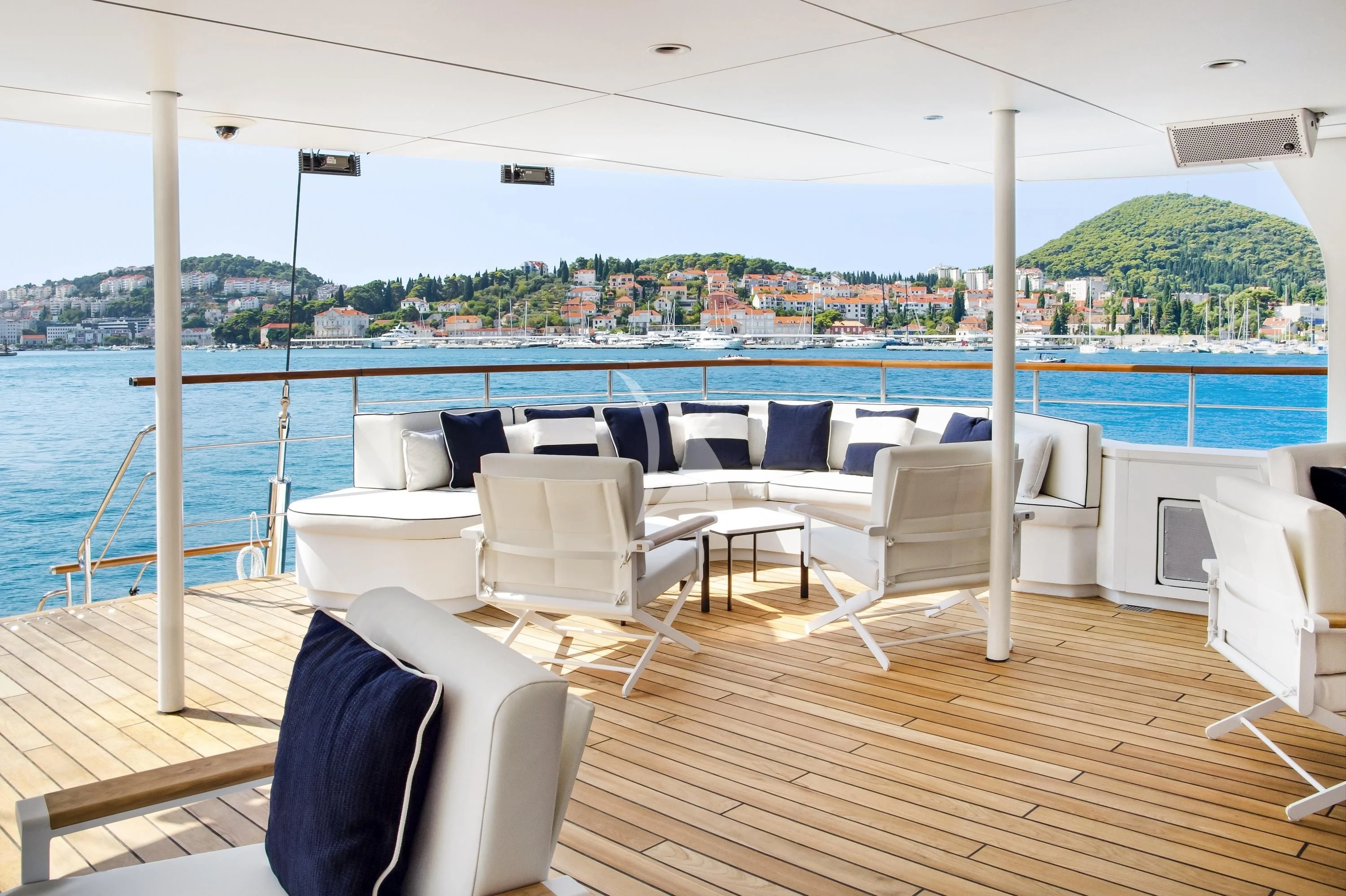 a boat deck with chairs and a body of water in the background aboard LE PONANT Yacht for Charter